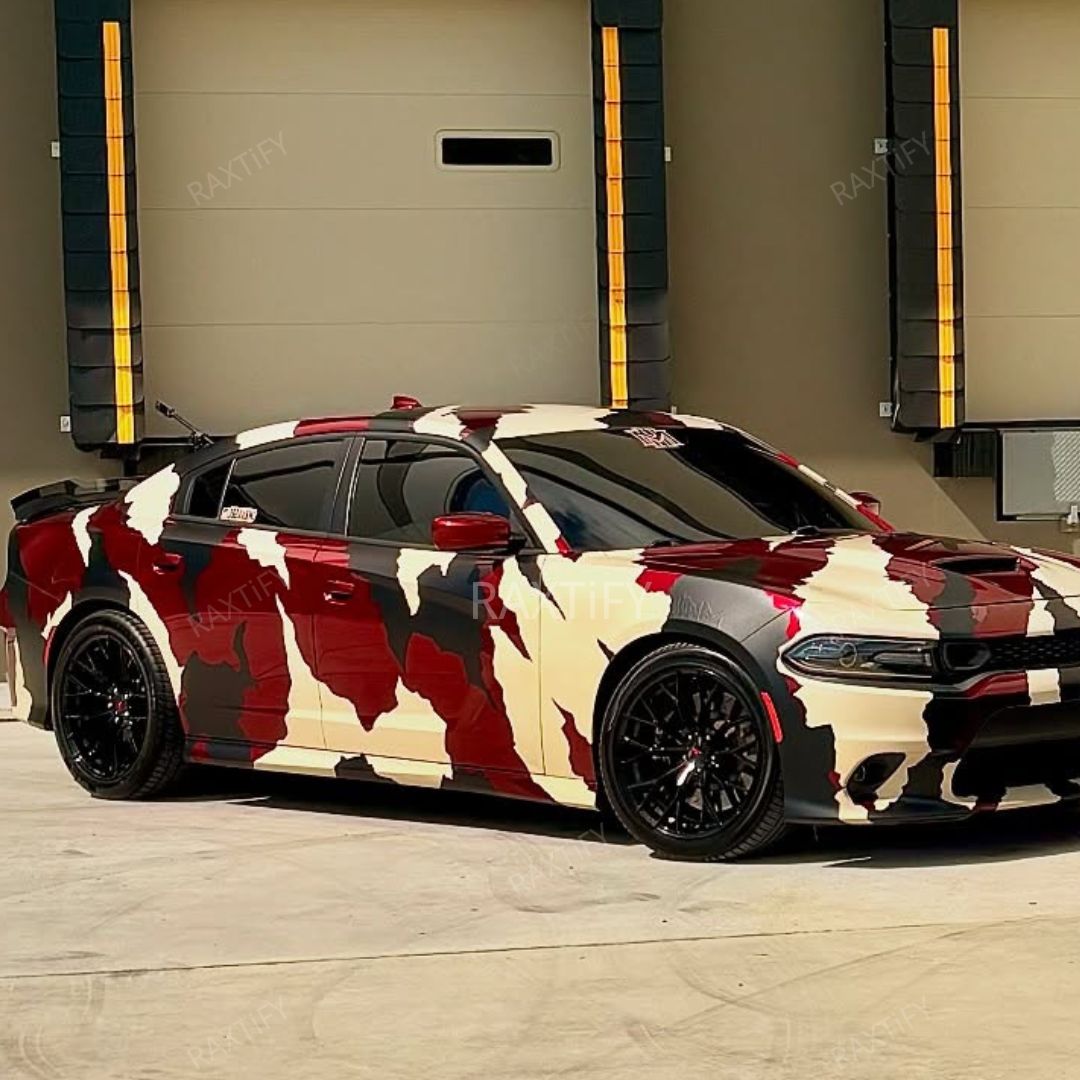 Camouflage-patterned car parked in front of a garage door.