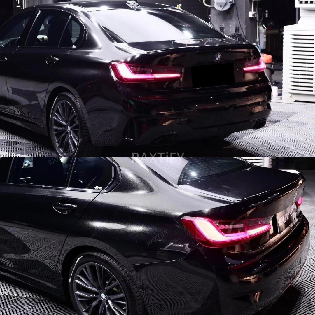 Black car with illuminated taillights on a reflective surface