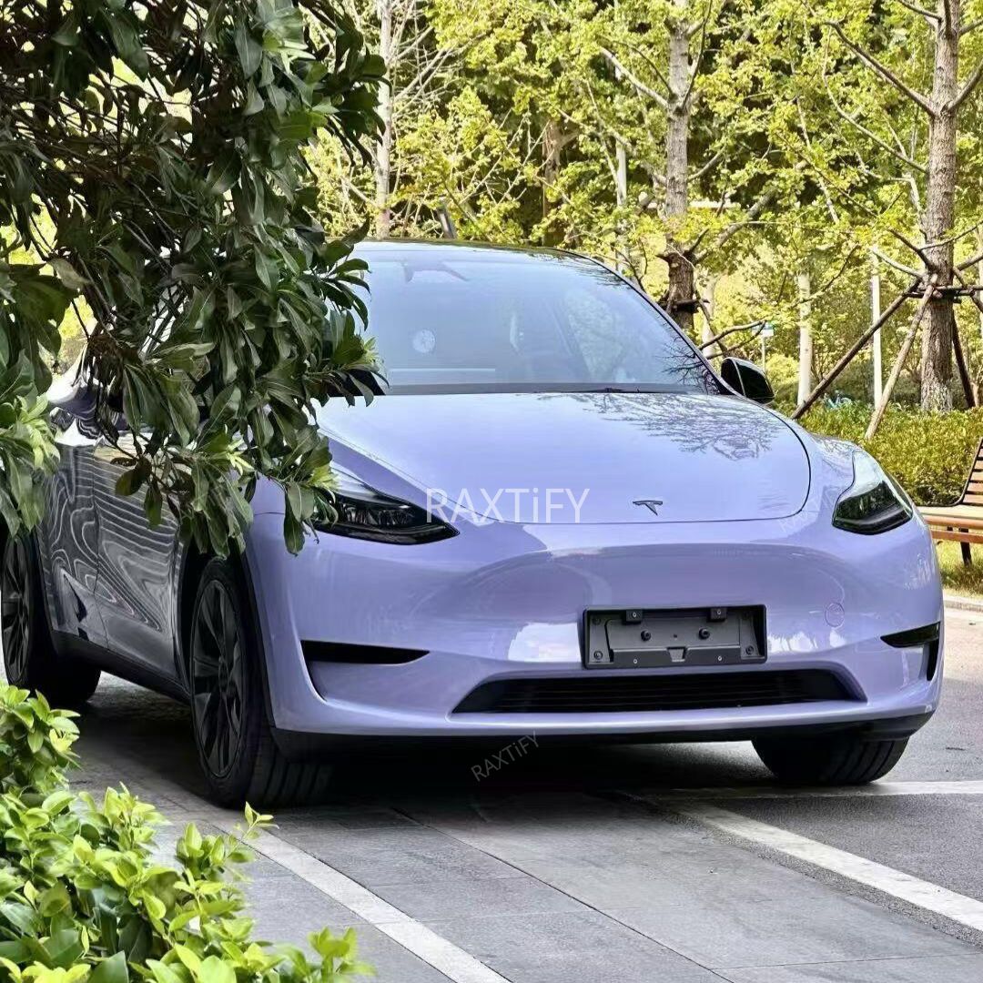 Electric car Tesla in Gloss Victoria’s Secret Purple Vinyl Wrap parked on a road with trees in the background